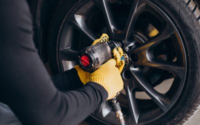 Car mechanic changing wheels in car